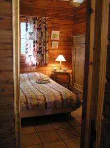una camera con un letto in una baita di tronchi di Residences Du Golf Des Roucous a Sauveterre Altre 25 foto