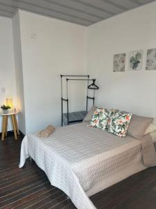 ein Schlafzimmer mit einem Bett mit einer weißen Tagesdecke in der Unterkunft Casa Ambrosía in Calarcá