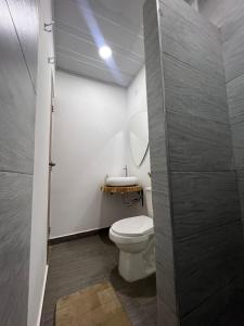 ein Badezimmer mit einem weißen WC und einem Waschbecken in der Unterkunft Casa Ambrosía in Calarcá