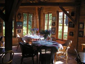 una sala da pranzo con tavolo, sedie e finestre di Residences Du Golf Des Roucous a Sauveterre