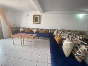 a living room with a couch and a table at Lilac's Garden - Cabo Negro - Résidence avec piscine in Cabo Negro +3 photos