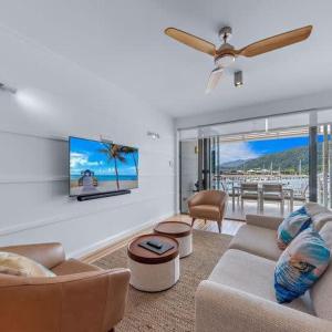 a living room with a couch and a ceiling fan at Marina Living with views and more in Airlie Beach