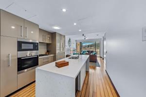 a kitchen with a white counter top and a stove top oven at Marina Living with views and more in Airlie Beach