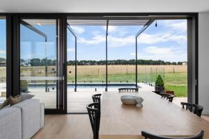 a dining room with a table and a large glass window at Curlewis Farm in Curlewis +6 photos