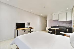 1 dormitorio con 1 cama grande y cocina en Ciel mini hotel, en Gyeongju