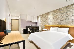 慶州市にあるCiel mini hotelのベッドルーム(大きな白いベッド1台付)、キッチンが備わります。