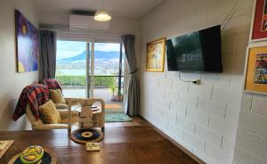 a living room with a couch and a table and a tv at Waterfront Abode - 2 bedrooms in Hobart