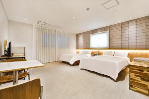 慶州市にあるCiel mini hotelのベッド4台とテレビが備わるホテルルームです。