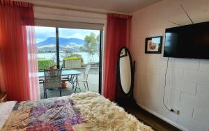 ein Schlafzimmer mit einem TV und einem Surfbrett neben einem Fenster in der Unterkunft Waterfront Abode - 2 bedrooms in Hobart