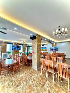 岑山的住宿－Khách sạn Xanh Tốt FLC Sầm Sơn，用餐室配有木桌和椅子