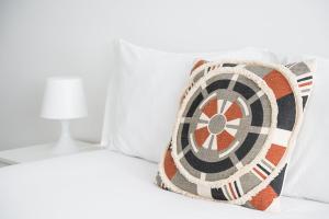 a bed with a dart pillow on it at GuestReady - A sunny moment in Porto in Porto +20 photos