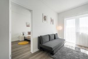 ein Wohnzimmer mit einem Sofa und einem Fenster in der Unterkunft GuestReady - A sunny moment in Porto in Porto
