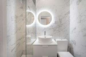 a white bathroom with a sink and a mirror at GuestReady - A sunny moment in Porto in Porto