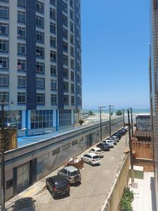 a row of cars parked in a parking lot next to a tall building at Apartamento na Praia dos Sonhos Perto do Mar em Itanhaém in Itanhaém