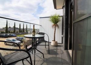 um pátio com uma mesa e cadeiras numa varanda em 239 High by Regional Escapes em Geelong