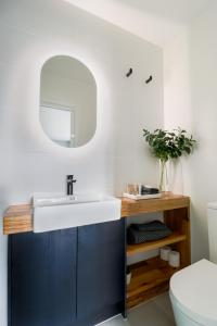 239 High by Regional Escapes في جيلونج: حمام مع حوض أبيض ومرآة