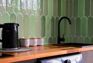 um balcão de cozinha com um balcão com uma chaleira e chávenas em 239 High by Regional Escapes em Geelong