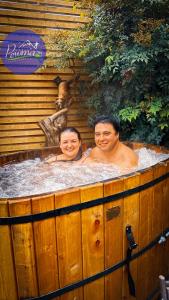a man and a woman in a hot tub at Cabañas Pewma Futrono in Futrono