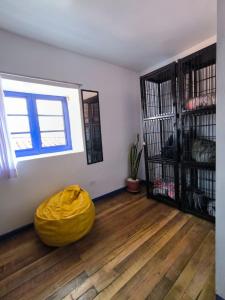 a room with a yellow ottoman on a wooden floor at Haku Hostel in Cusco