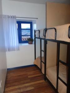 two bunk beds in a room with a window at Haku Hostel in Cusco