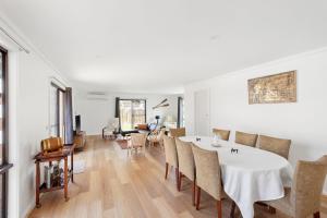 a living room with a white table and chairs at Jacaranda Cottage at the Beach in Cowes