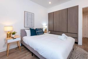 Schlafzimmer mit einem großen weißen Bett und einem Kopfteil aus Holz in der Unterkunft Luxury 2 Bedroom In Larchmont Sleeps 4 W. Roof Top in Los Angeles