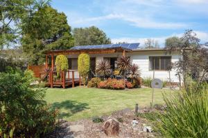 a house with solar panels on top of it at Jacaranda Cottage at the Beach in Cowes
