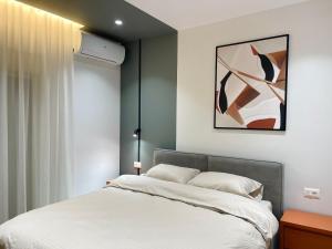 een slaapkamer met een bed en een schilderij aan de muur bij Luxurious Dreamy seaview apartment in Durrës