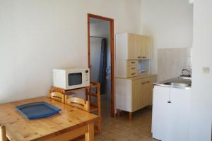 una pequeña cocina con mesa y microondas en Residence Thalassa en Calvi