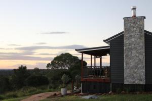 a house with a stone chimney and a deck at The Firebreak 