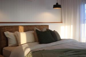 una camera da letto con un letto con cuscini bianchi di The Firebreak 