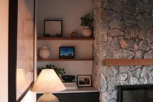 a lamp in a living room next to a stone fireplace at The Firebreak 