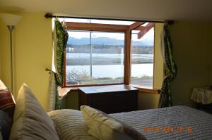 um quarto com uma cama e uma janela com vista em Estuary House Reflexology B&B em Courtenay