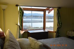 a bedroom with a bed and a window with a view at Estuary House Reflexology B&B in Courtenay
