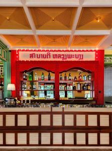 a restaurant with a bar in the middle of it at Senglao Boutique Hotel Luang Prabang in Luang Prabang