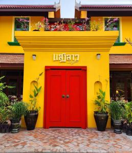 a yellow and red building with a red door at Senglao Boutique Hotel Luang Prabang in Luang Prabang