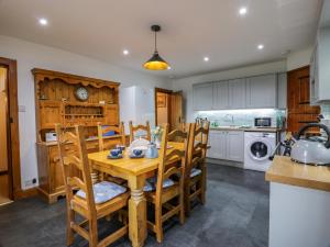 a kitchen and dining room with a wooden table and chairs at Craggs Cottage in Smailholm