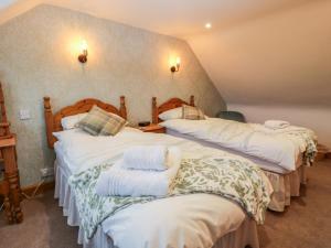 a bedroom with two beds with towels on them at Craggs Cottage in Smailholm