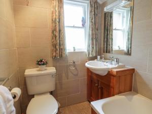 ein Badezimmer mit Toilette und Waschbecken und einem Fenster in der Unterkunft Craggs Cottage in Smailholm + 22 Fotos