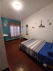 een slaapkamer met een bed met een blauwe deken bij El Boquerón - Hospedaje in Huanchaco