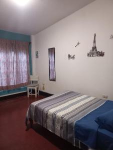 1 dormitorio con 1 cama y una ventana con la torre Eiffel en El Boquerón - Hospedaje en Huanchaco