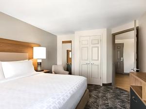 a hotel room with a bed and a mirror at Candlewood Suites Champaign-Urbana University Area, an IHG Hotel in Champaign