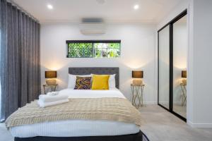 1 dormitorio con 1 cama grande con almohadas amarillas en Hamptons Spa Villa - Luxury 3 bedroom 2 bathroom home with outdoor Hot tub en Edge Hill