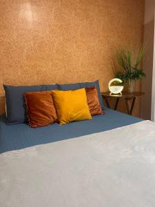 a bed with two colorful pillows on top of it at Quarto em AP compartilhado Ponta da areia in São Luís