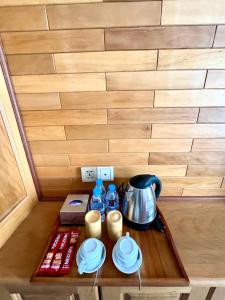 Môndól Kiri的住宿－Ellieza Motel，茶壶和盘子桌子