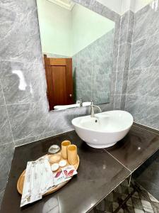 uma casa de banho com um lavatório e um espelho em Ellieza Motel em Môndól Kiri