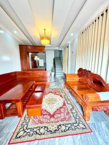 a living room with wooden furniture and a rug at Ellieza Motel in Môndól Kiri