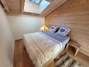 a bedroom with a bed in a wooden cabin at Appartement Les Gets, 3 pièces, 5 personnes - FR-1-598-162 in Les Gets