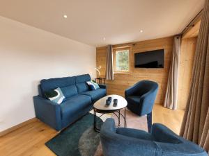 a living room with a blue couch and two chairs at Appartement lumineux 3* avec terrasse, 2 chambres, proche centre et pistes, garage inclus - FR-1-598-163 in Les Gets