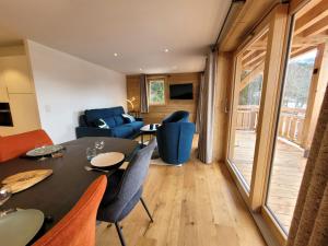 a living room with a dining room table and chairs at Appartement lumineux 3* avec terrasse, 2 chambres, proche centre et pistes, garage inclus - FR-1-598-163 in Les Gets